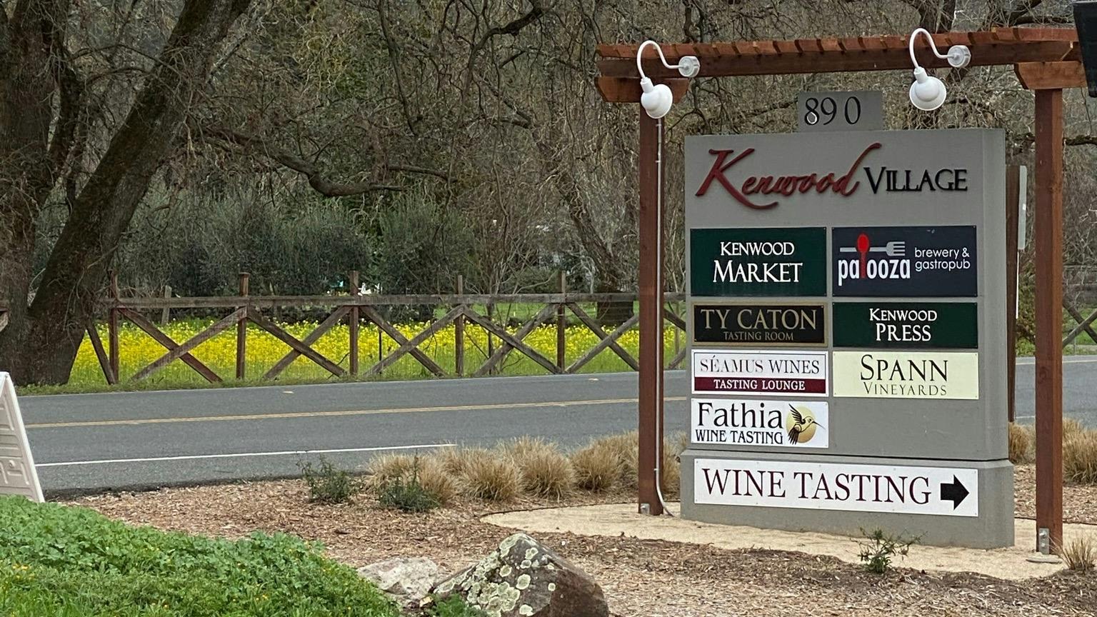 The Kenwood Village monument sign on Highway 12, listing Kenwood Market, Palooza Brewery & Gastropub, Ty Caton, Kenwood Press, Séamus Wines, Spann Vineyards and Fathia
